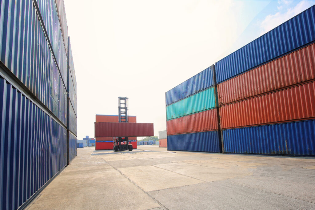 Container carried by lift at cargo port ship yard storage facility